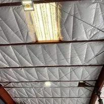 The ceiling of a building with a light hanging from it.